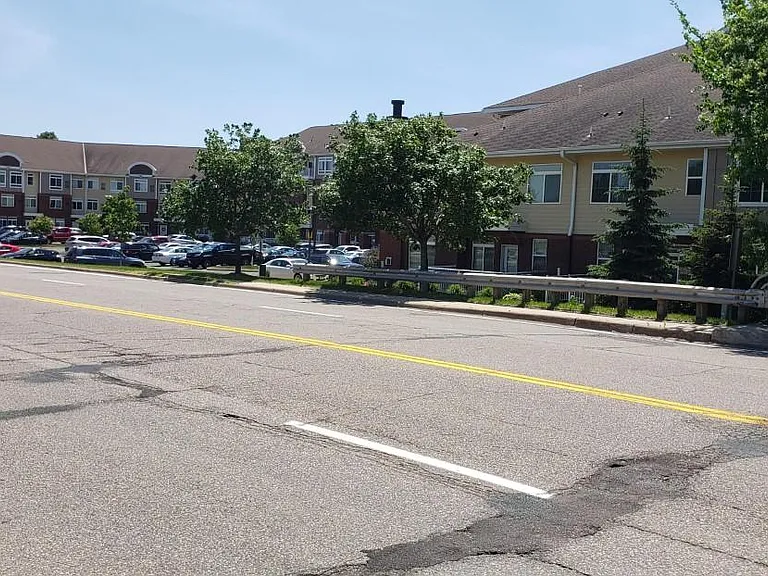 Cross street view shows sidewalk for convenient pedestrian travel to the shopping village