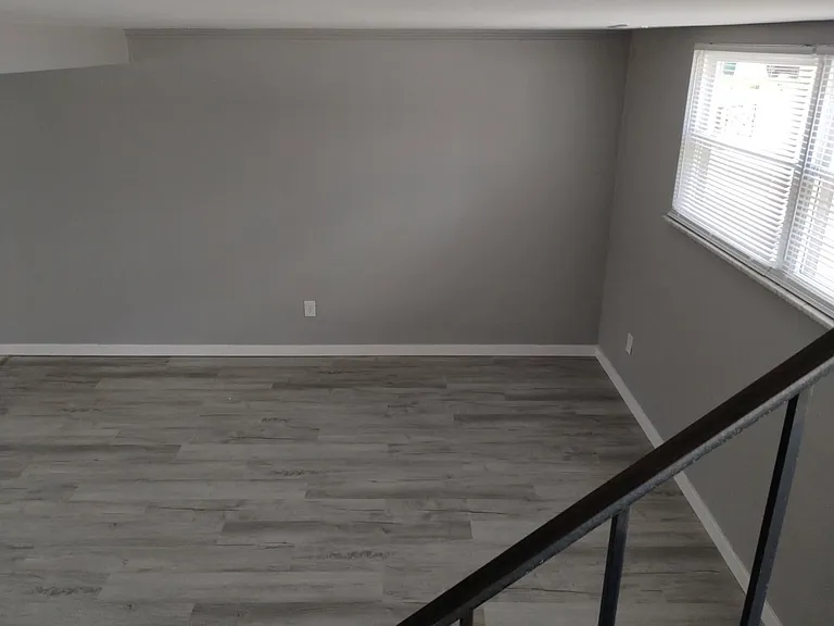 LIVING ROOM WITH NEW FLOORS, PAINTING & WINDOWS.