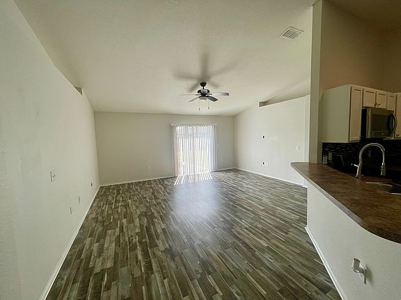 Bright, spacious open-concept living area with high ceilings and easy-care flooring.
