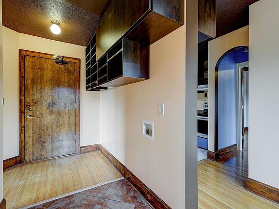 Entrance to unit with open and closed storage and hanging coat rack.