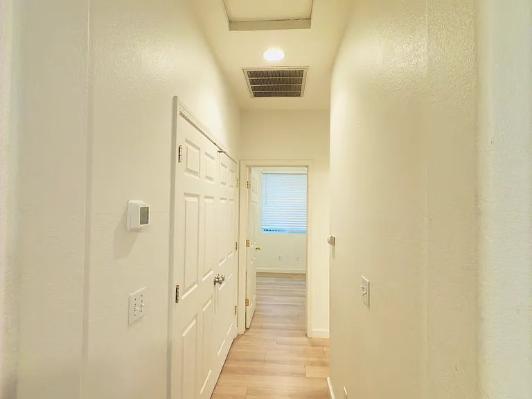 Inviting hallway leading to the bedrooms and bathroom, offering a seamless flow and easy access to the private spaces of the home.