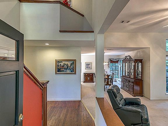 Vaulted ceiling entry way with wood flooring greets you as you enter the home.
