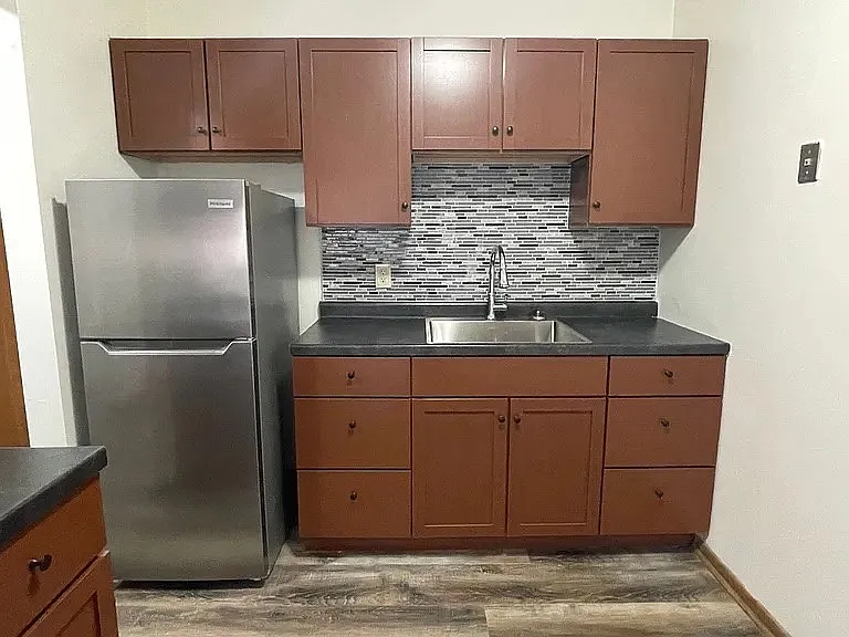 Step into a spacious kitchen at LS Capital Group, featuring modern appliances, sleek cabinets, and stylish backsplash. This inviting space is perfect for culinary enthusiasts and entertaining. Explore more today!