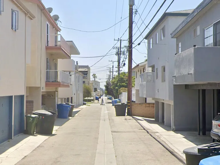 Back of the building with a carport and balcony. Alleyway behind the building looking south.