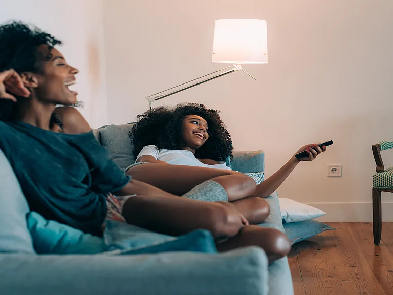 Sisters watching a movie in apartment