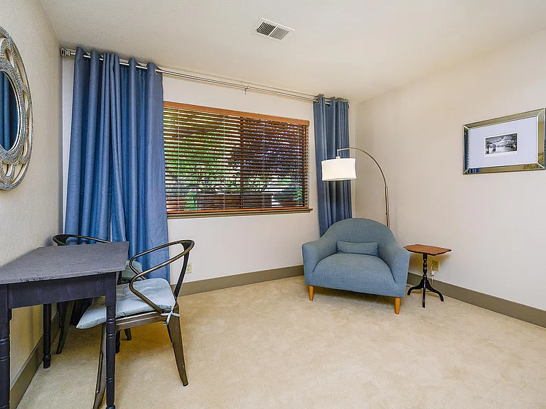 The sitting area of the Master bedroom, with large windows looking into the trees.
