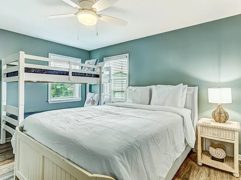 Guest room with queen bed and twin bunks.