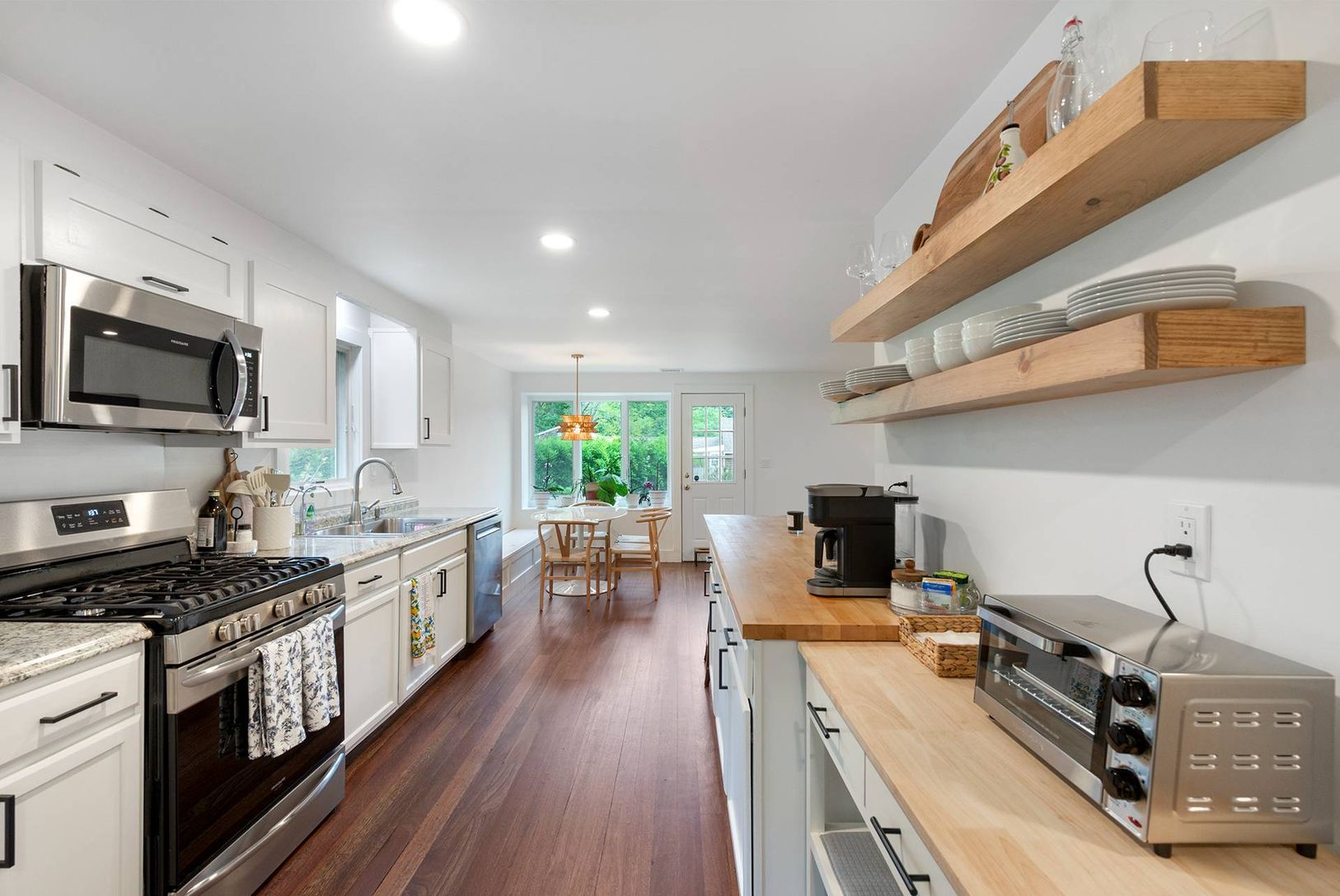  reclaimed wood shelving mixed with custom cabinetry provides plenty of storage in the open kitchen