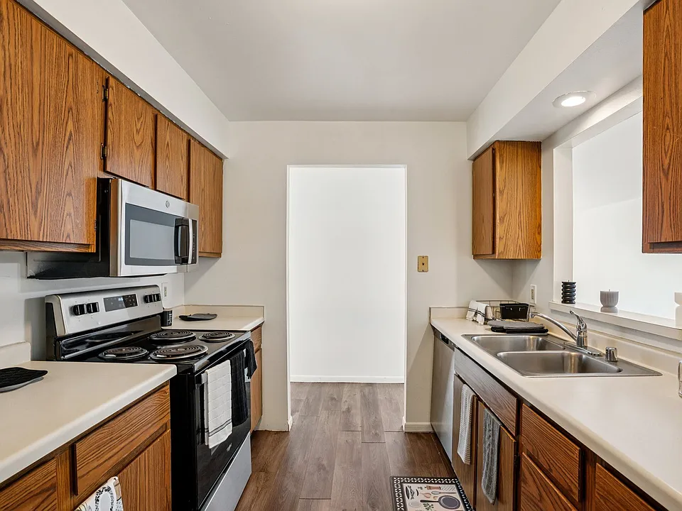 Cook with ease in kitchens featuring warm wood cabinetry and convenient stove top ovens, professionally operated by Highlands Vista Group.