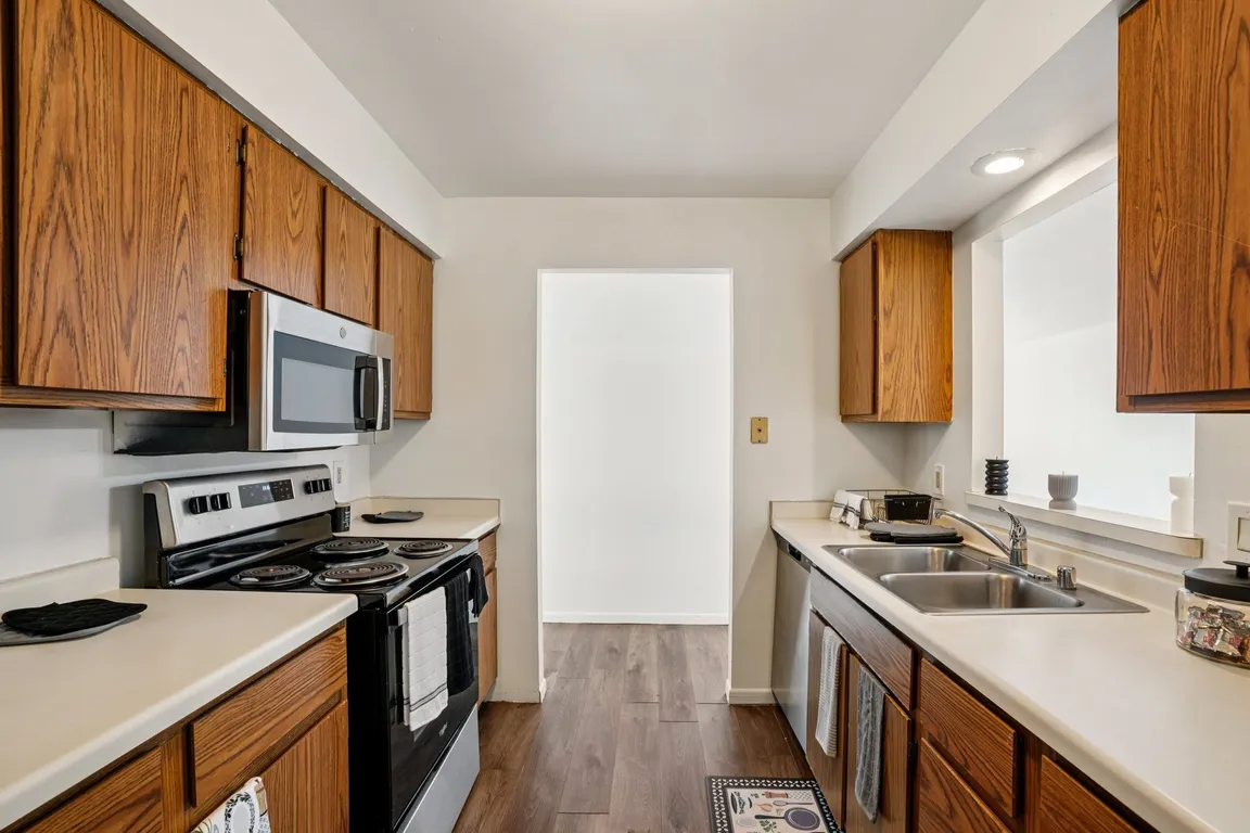 Cook with ease in kitchens featuring warm wood cabinetry and convenient stove top ovens, professionally operated by Highlands Vista Group.