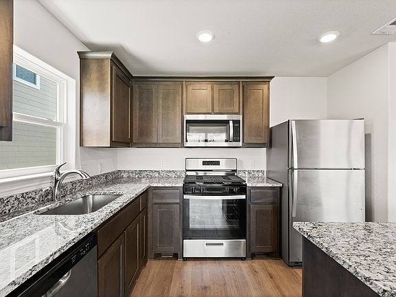 The upgraded kitchen has sprawling granite countertops.