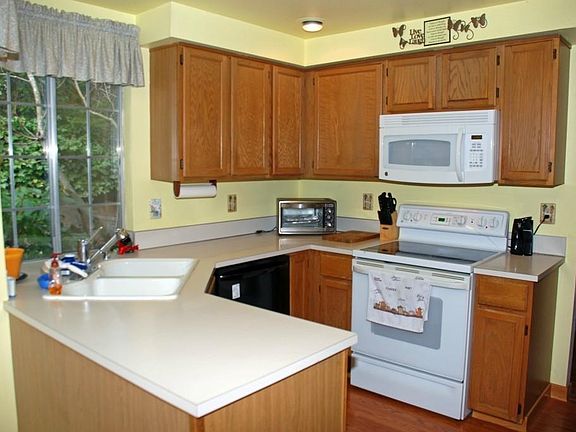 Kitchen includes microwave, refrigerator, oven and electric