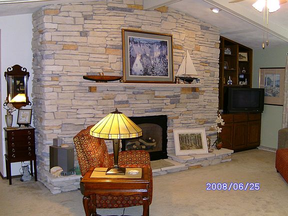 Floor to ceiling ledgestone gas insert fireplace in livingroom