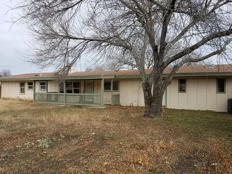 Rear view of fenced in back yard, garden also shown