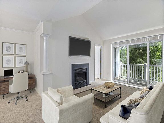 Bright living room with fireplace and private balcony