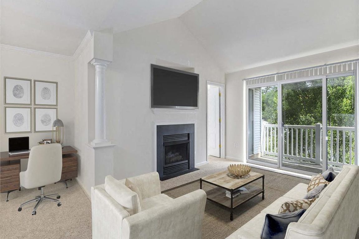 Bright living room with fireplace and private balcony