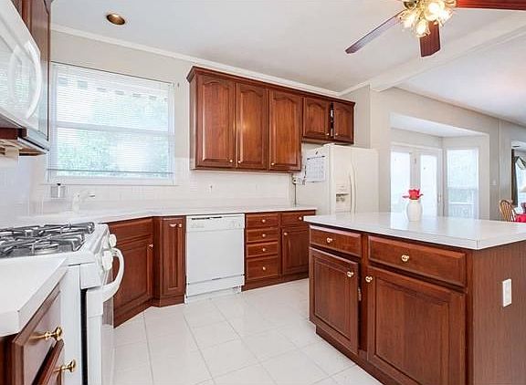 Another great view of the kitchen - notice the corner window, gas stove & ceiling fan.