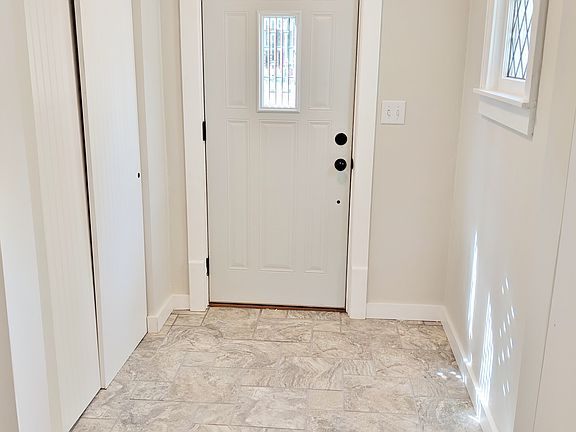 Tiled foyer with coat closet