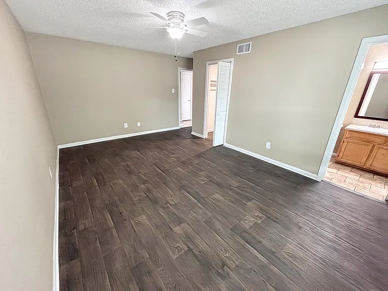A spacious living room with durable wood-style flooring enhances comfort and style.