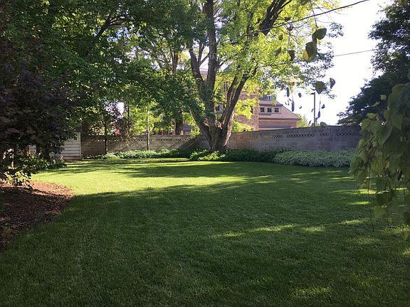 Large backyard with cinder block walls (fence) and iron gate