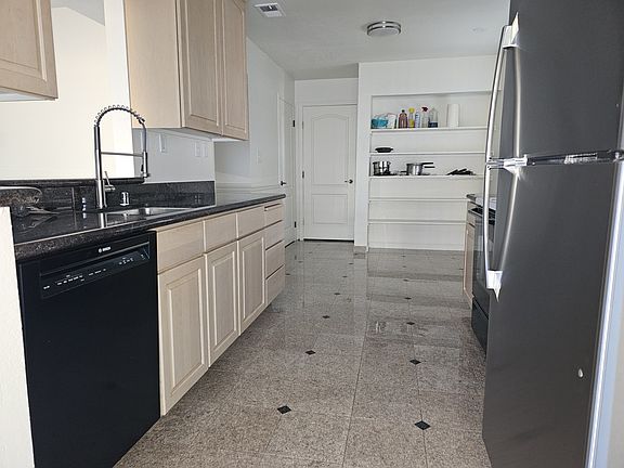 Kitchen with new refrigerator, dishwasher, and microwave.