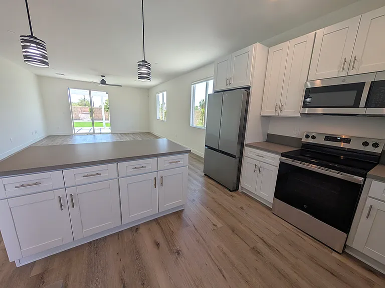 Kitchen and island overlooking open concept dining/living room. New appliances, good cabinet storage