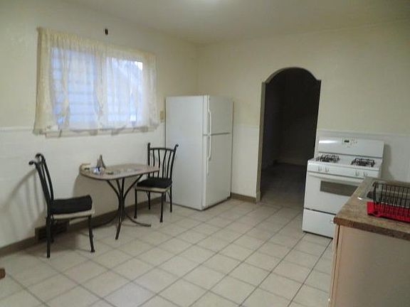 Kitchen with tile floor and stove / refrigerator