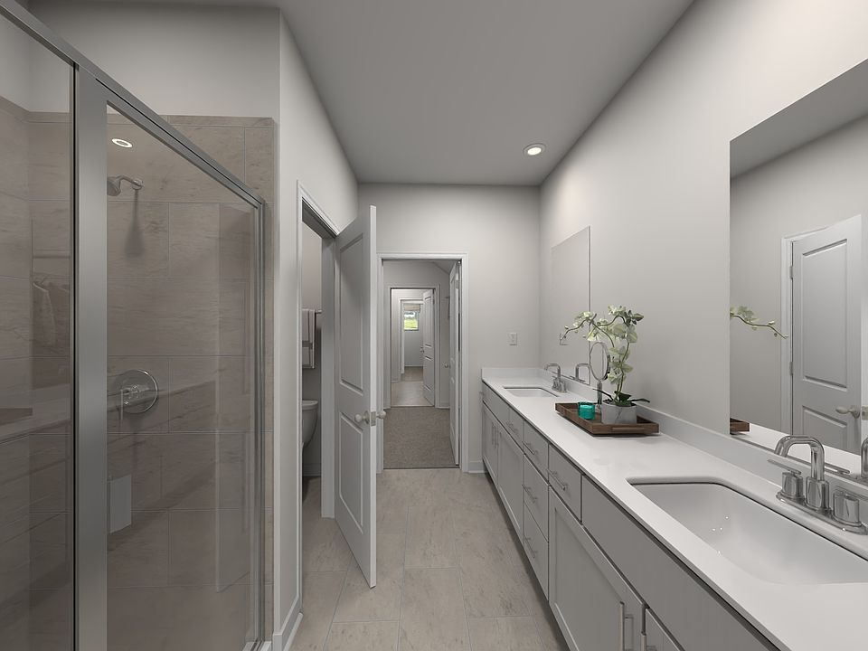 The primary bathroom offers dual vanity sinks and a walk-in shower.