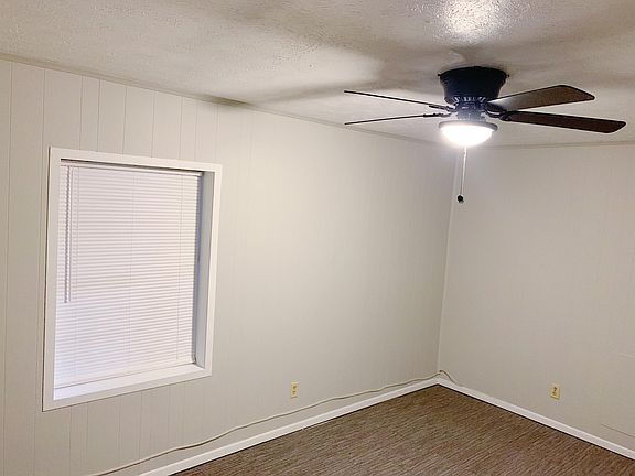Bedroom 1 - freshly painted bedroom featuring new ceiling fan and blinds.