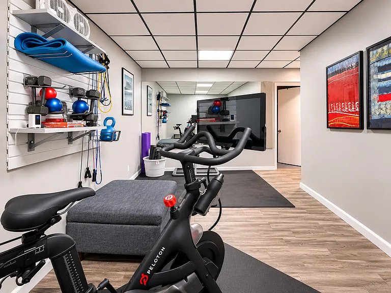 Utility room with exercise equipment including a Peloton bike