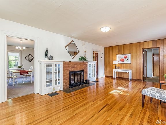 View from Entry into Living Room - Classic Features of Brick Faced Fireplace w/Built-In Cabinets & Hardwood Floors!  Large Dining Room thru the Doorway.