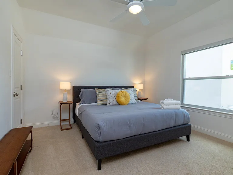 Bright and modern upstairs bedroom featuring a plush king-sized bed.