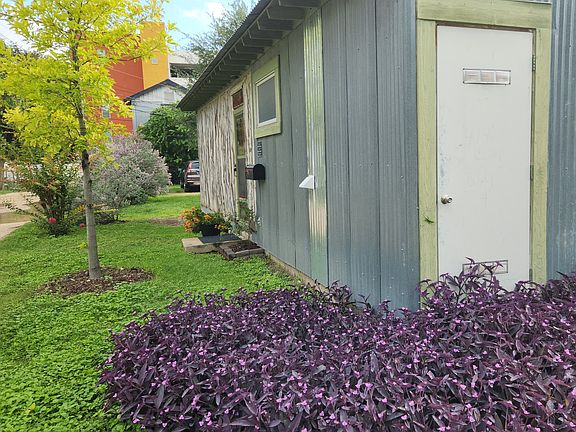 Front of house, mailbox, as seen from parking area (white door with green trim in foreground is water heater closet.)