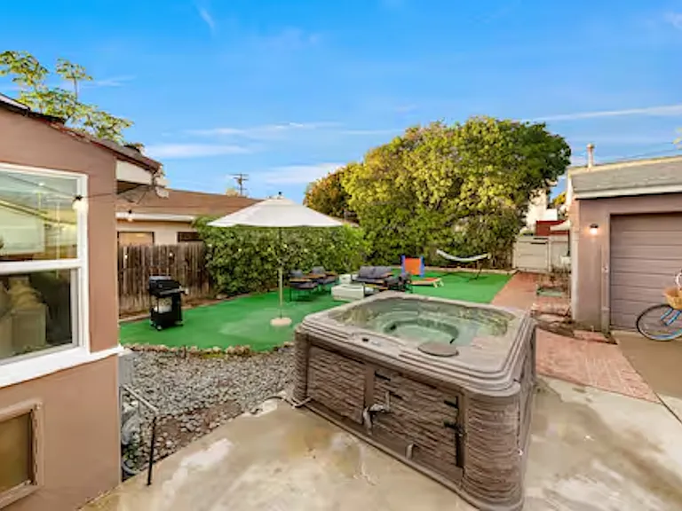 Private outdoor hot tub that comfortably seats 6_8 guests, perfect for unwinding after a day at the beach and enjoying relaxed evenings under the open sky.