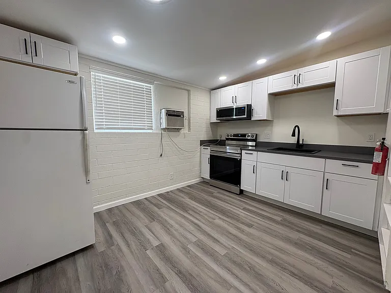 Kitchen with new cabinets, range and microwave.