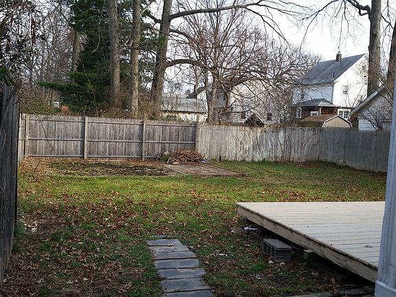 view of large fenced backyard with deck