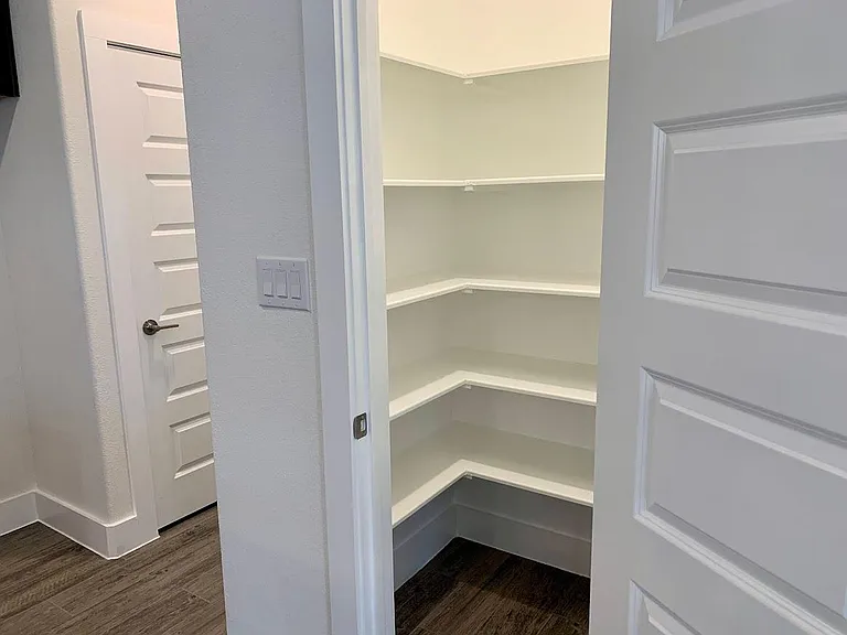 Kitchen has walk in pantry with abundant storage shelves.
