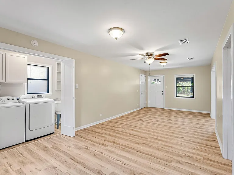 Den with laundry room doors open.