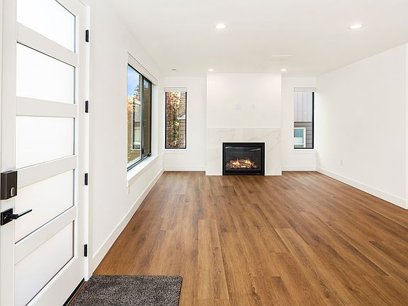 Spacious living room with gorgeous gas fireplace and custom blinds throughout.