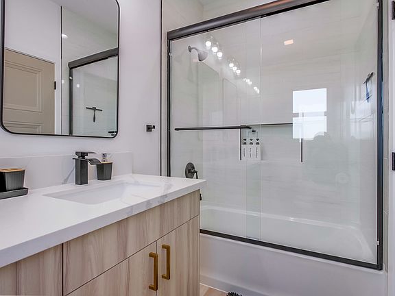 Primary bathroom featuring a beautiful bathtub and double-sink vanity.