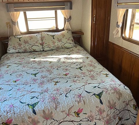 RV Queen bed. Windows on 3 sides. 2 closets & overhead storage units. Storage area under bed.