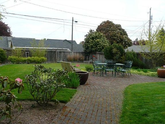 Fully fenced lush yard with gardens and fruit trees.