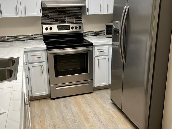 Kitchen. Tile counter top. Vinyl plank floor. Pantry.