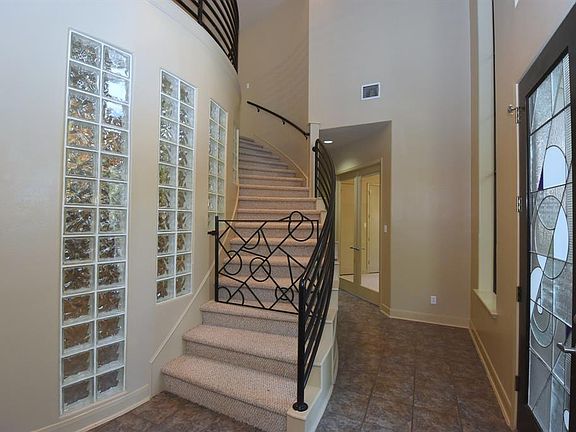 The stairway gently sweeps to the second floor. Double doors to the right of the stairway are to a secondary downstairs guest be