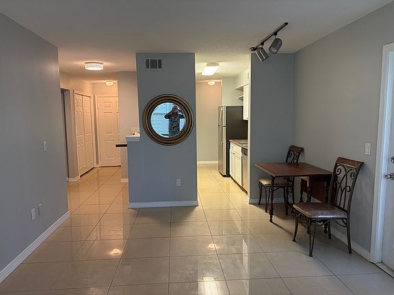 Living room looking to front door. Laundry closet on the left (double doors). Guest bedroom/bath on the left. small dinette - door to porch on right