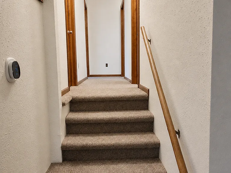 Stairs, hallway leading to three bedrooms.