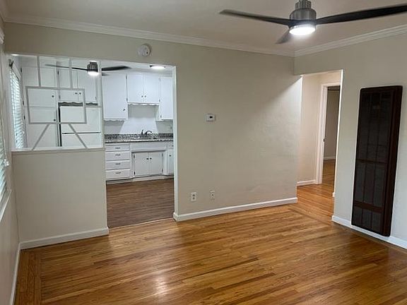 Looking across living room, to kitchen, from front door. Hall to bath, bedroom and office on right. Wall heater.