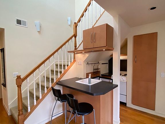 Kitchen with stove, oven, sink, microwave, pantry, and eat-in bar