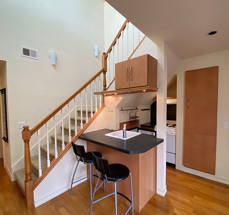 Kitchen with stove, oven, sink, microwave, pantry, and eat-in bar