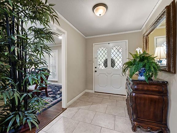 Entryway featuring crown molding and light tile patterned floors